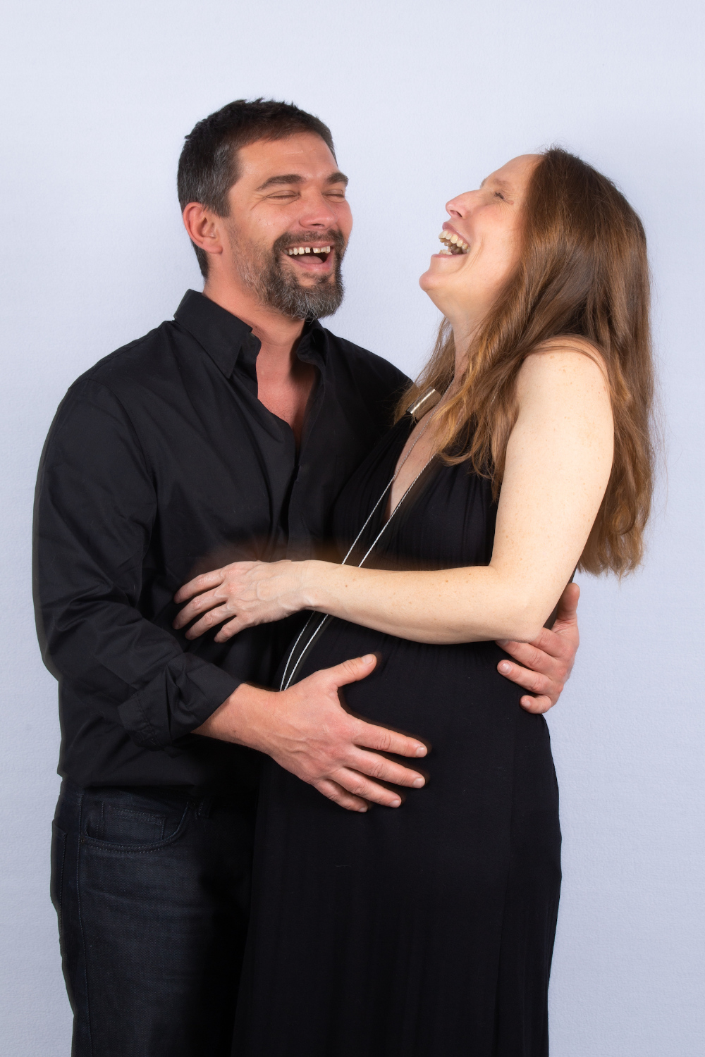 couple tout sourire d'une femme enceinte et de son compagnon