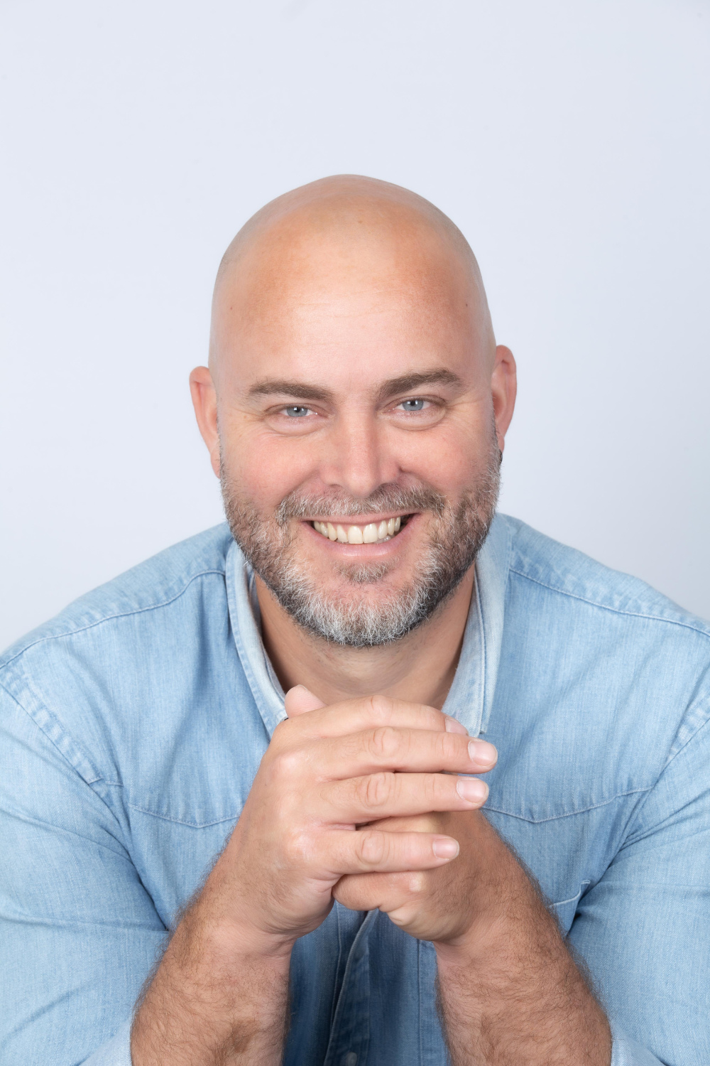 portrait professionnel d'un homme aux yeux clairs et en chemise bleue